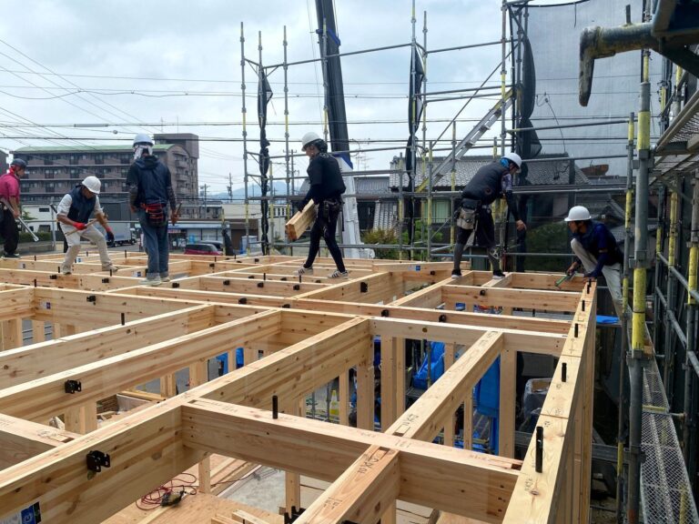 上棟現場で木造の梁を組み上げる大工たち