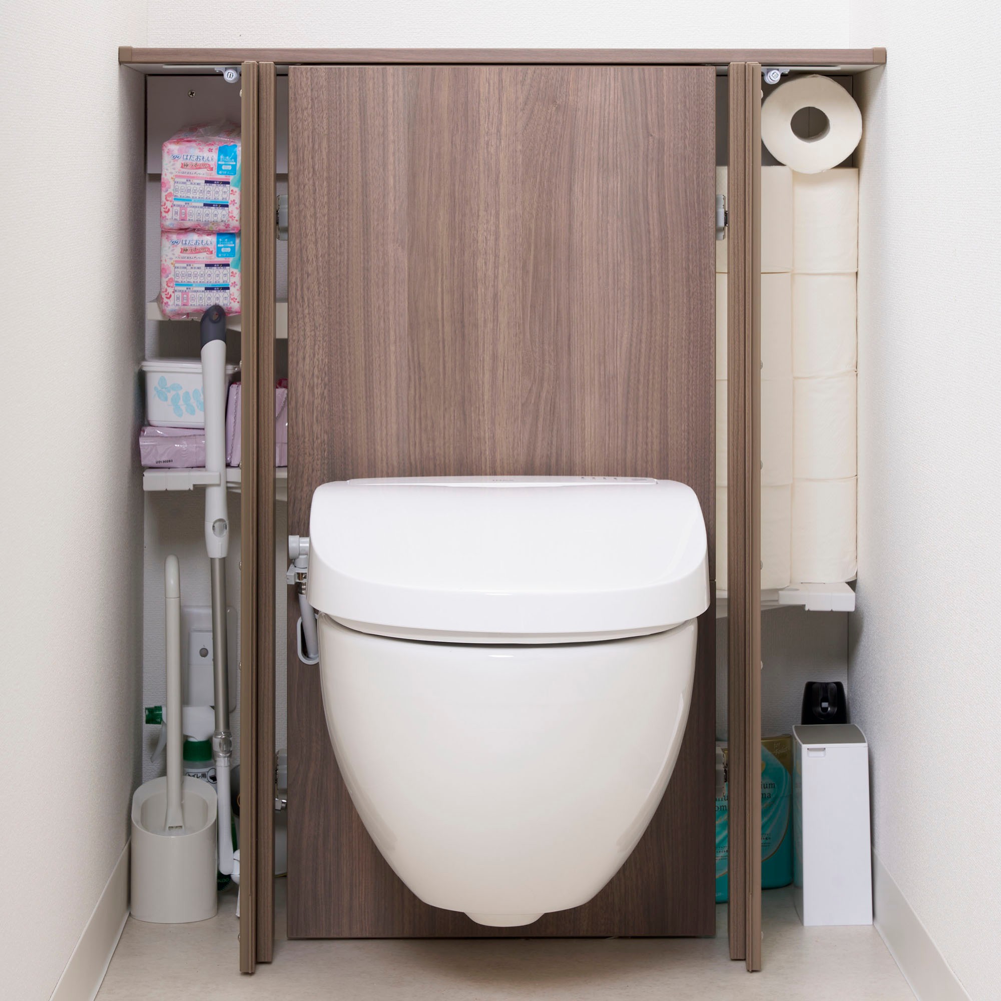 LIXIL「フロート トイレ」の背面キャビネットを開き、トイレットペーパーや掃除用品を収納した一例